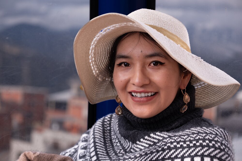 Portrait of Aracely smiling inside a cable car in La Paz.