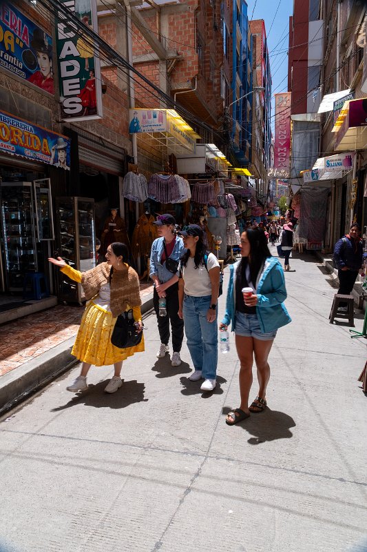 Aracely leading guests on a walking tour through a street market in La Paz.