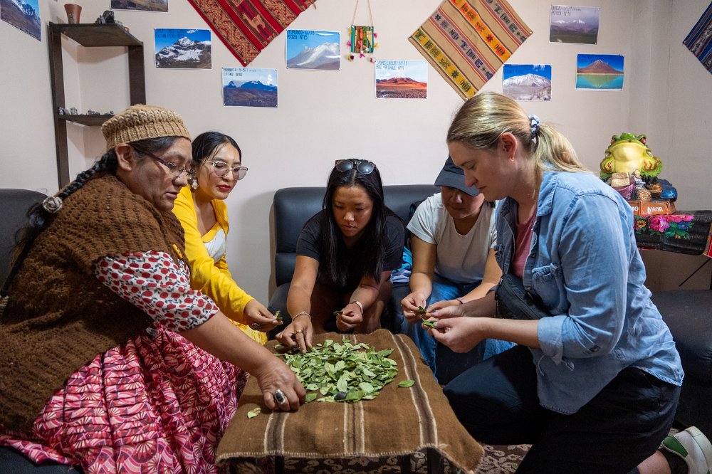 Aracely sharing a traditional coca leaf experience with guests.